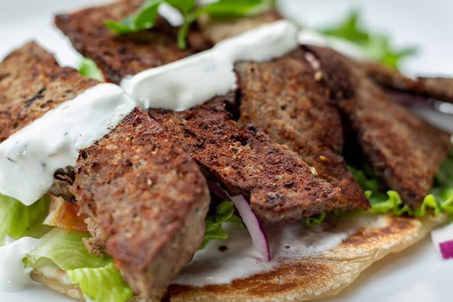Beef gyro with tomato, onion, lettuce, and tzatziki, served on pita bread